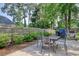 Spacious backyard featuring a patio area with a table and grill, surrounded by greenery and a wooden fence at 900 47Th Ave. N, Myrtle Beach, SC 29577