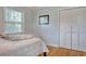 Bright bedroom featuring wood floors, a bed with patterned bedding and closet with folding doors at 900 47Th Ave. N, Myrtle Beach, SC 29577