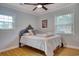 Well-lit bedroom with hardwood floors, a ceiling fan, and white and grey bedding at 900 47Th Ave. N, Myrtle Beach, SC 29577