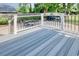Back deck with gray wood floors and white railing, with a table and chairs perfect for entertaining at 900 47Th Ave. N, Myrtle Beach, SC 29577