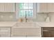 Farmhouse style sink under a window with white cabinetry and modern faucet at 900 47Th Ave. N, Myrtle Beach, SC 29577