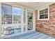 Enclosed patio area featuring brick walls, glass windows and door, and a blue wooden floor at 900 47Th Ave. N, Myrtle Beach, SC 29577