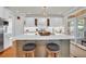 Bright kitchen features a spacious island with seating, white cabinetry, and stainless steel appliances at 92 High Hammock Way, Pawleys Island, SC 29585