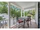 Covered porch features outdoor seating and views of the surrounding trees at 92 High Hammock Way, Pawleys Island, SC 29585
