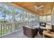 Relaxing screened porch features comfortable seating and views of the green neighborhood trees at 92 High Hammock Way, Pawleys Island, SC 29585
