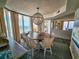 Open dining room with seating for six and a chandelier, with glimpses of the living room and ocean view at 9650 Shore Dr. # 2207, Myrtle Beach, SC 29572