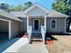 Charming single story home exterior with covered porch, painted steps, and lush landscaping at 1000 Weldon Ln., Conway, SC 29526