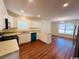 Well-lit kitchen showcasing hardwood flooring, updated appliances, white cabinetry, and a dining area at 1000 Weldon Ln., Conway, SC 29526