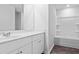 Bright bathroom with white cabinets, sink, mirror, and tub/shower combo with built-in shelving at 1008 Sentinel Ct., Little River, SC 29566
