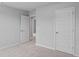 Neutral bedroom with light gray walls, neutral carpet, and multiple white doors leading to other rooms at 1008 Sentinel Ct., Little River, SC 29566