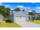 Charming two-story home featuring a light blue exterior, attached garage, and well-manicured lawn at 1008 Sentinel Ct., Little River, SC 29566