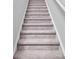 Carpeted stairway offering a smooth transition between floors in a neutrally decorated home at 1008 Sentinel Ct., Little River, SC 29566