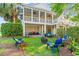 Expansive two-story porch overlooks beautiful backyard with fire pit and colorful Adirondack chairs at 12 Jerry Ct., Pawleys Island, SC 29585
