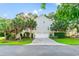 Rear view of the home with a two-car garage, lush landscaping, and a vibrant lawn at 12 Jerry Ct., Pawleys Island, SC 29585