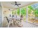 Expansive outdoor porch with wood deck and dining table featuring surrounding green trees at 12 Jerry Ct., Pawleys Island, SC 29585