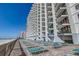 Beachfront condo building with multiple balconies and lounge seating area at 1210 N Waccamaw Dr. # 602, Murrells Inlet, SC 29576