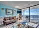 Living room with a comfortable couch and a view of the beach from the balcony at 1210 N Waccamaw Dr. # 602, Murrells Inlet, SC 29576