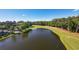 An aerial view displays a golf course and pond alongside a residential building complex at 1221 Tidewater Dr. # 2112, North Myrtle Beach, SC 29582