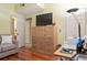Bedroom featuring a wooden dresser with a TV, desk, chair, and hardwood flooring at 1221 Tidewater Dr. # 2112, North Myrtle Beach, SC 29582