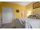 Yellow bedroom with white furniture, including a queen bed, nightstand and a closet at 1221 Tidewater Dr. # 2112, North Myrtle Beach, SC 29582