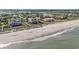 Aerial view of luxury beachfront homes, featuring private boardwalks to the ocean, nestled between lush greenery and sand at 123 Pioneer Loop, Georgetown, SC 29440