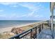 Balcony with decorative iron railings overlooking a sandy beach and ocean featuring wooden walkways at 123 Pioneer Loop, Georgetown, SC 29440