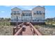 Coastal home featuring multiple balconies and a private boardwalk leading to the beach, blending luxury and accessibility at 123 Pioneer Loop, Georgetown, SC 29440