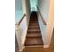 Carpeted stairs with white railing and stained banister lead to the upper level of the home at 1248 Lady Bird Way, North Myrtle Beach, SC 29582