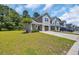 Townhome featuring a lush green lawn and a concrete driveway leading to the garage at 132 Machrie Loop # A, Myrtle Beach, SC 29588