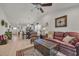 Inviting living room with wood-look floors, ceiling fan, comfortable seating and open layout to kitchen at 132 Machrie Loop # A, Myrtle Beach, SC 29588