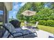 Outdoor patio area with lounge chair, table, umbrella and grill overlooking a wooded area at 132 Machrie Loop # A, Myrtle Beach, SC 29588