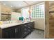 This bathroom has a double vanity, decorative mirror and cabinets, and stone tile floors at 1325 Clipper Dr., North Myrtle Beach, SC 29582