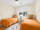 Charming bedroom featuring twin beds with bright orange comforters and a decorative floral rug at 1325 Clipper Dr., North Myrtle Beach, SC 29582