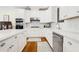 Bright kitchen features white cabinets, stainless steel appliances, and a spacious island with stone countertops at 1325 Clipper Dr., North Myrtle Beach, SC 29582