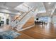 Bright foyer with hardwood floors, grand staircase, and views into the dining and living areas at 139 Pioneer Loop, Georgetown, SC 29440