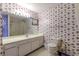 Classic bathroom with floral wallpaper, a large vanity, and a well-lit mirror at 1437 Baldwin Ct. # 1437, Little River, SC 29566