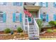 Charming entrance with staircase, American flag, and neatly landscaped bushes at 1437 Baldwin Ct. # 1437, Little River, SC 29566