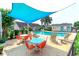 Relaxing poolside seating area with tables and chairs under a shade covering at 1437 Baldwin Ct. # 1437, Little River, SC 29566