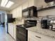 The kitchen features granite countertops and black appliances with white cabinetry at 1501 S Ocean Blvd. # 239, Myrtle Beach, SC 29577