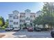 Three-story condo with white siding, black shutters, and multiple balconies at 1505 Lantern Rest Dr. # 301, Myrtle Beach, SC 29579