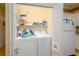 Functional laundry area featuring a washer, dryer, storage shelf, and a nearby refrigerator at 1505 Lantern Rest Dr. # 301, Myrtle Beach, SC 29579