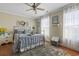 Cozy bedroom boasts hardwood floors, a ceiling fan, and soft natural light from the windows at 1609 Bridgebrook Ln., Conway, SC 29527