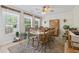 Light-filled dining area with a large wood table, chairs, and ample natural light from surrounding windows at 1609 Bridgebrook Ln., Conway, SC 29527