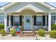 Charming front porch with a pale blue door, 'Welcome' sign, black shutters and decorative seating at 1609 Bridgebrook Ln., Conway, SC 29527
