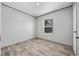 A bedroom with wood-look floors, neutral walls, a window, and an open doorway at 1962 Pint Circle, Longs, SC 29568