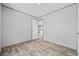 A bedroom with wood-look floors, neutral walls, a window and an open doorway at 1962 Pint Circle, Longs, SC 29568