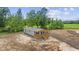 Aerial view of a single-story home surrounded by trees and a freshly graded lot at 1962 Pint Circle, Longs, SC 29568