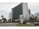 A view of Bluewater Resort from the street with a sign in front and a view of the pool at 2001 S Ocean Blvd. # 1504, Myrtle Beach, SC 29577