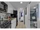 Efficient kitchen with white cabinetry, black appliances and tile flooring adjoins the home's bathroom and bedroom at 2001 S Ocean Blvd. # 1504, Myrtle Beach, SC 29577