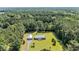 Aerial view of a home surrounded by lush greenery, with a long driveway and large garage on the property at 203 Warbler St., Georgetown, SC 29440